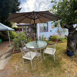 Glass top outdoor table and four matching chairs with cushions Homeless glass, top outdoor table and four matching chair, chairs with umbrella and cus