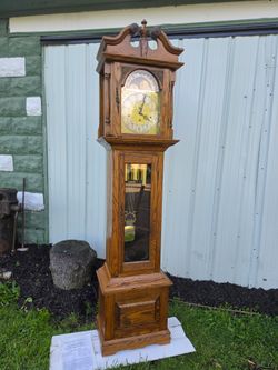 Stunning Emporer Grandfather Clock is Crafted from Solid Oak finish. This Emperor brand timepiece has a decorative brass dial with a moon phase sub-d