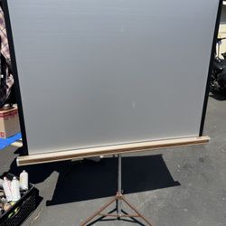 Vintage Da-Lite  Silver Pacer Tripod Projection Screen,  Movies & Slideshows. Measurements: 49" w X 52” h. Rolls up and down, folds for storage. 