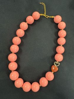 collar chicle con bolas en color naranja y corazon carmelita Bubblegum-style necklace with orange beads  and a brown heart.