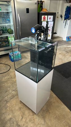 25 gallon aquatop saltwater aquarium with supplies and a light