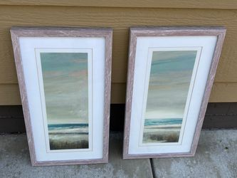 A pair of framed coastal beach prints