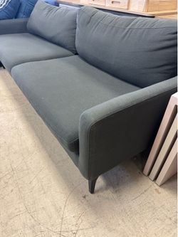 gray upholstered sofa features a minimalist, modern design with square arms - 84”