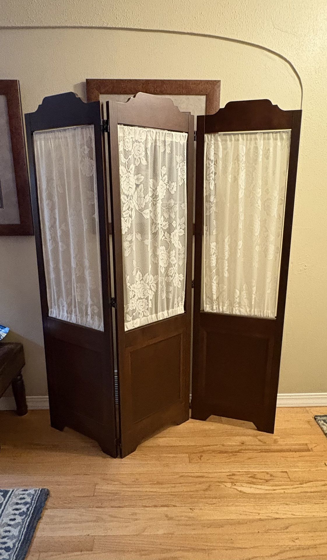 Vintage brown wood folding room divider with white lace curtain panels
