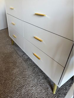 White dresser with gold legs and handles