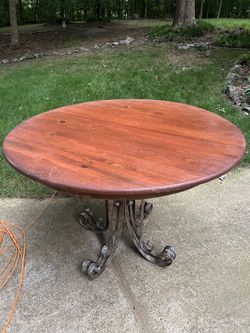 Wood round table with ornate metal base made in Mexico. Vintage 44” wide x 30” tall