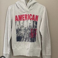 American Eagle Outfitters hoodie is a gray pullover featuring a "Vintage American 1977" graphic design, Get ready to rock a stylish and comfortable ho