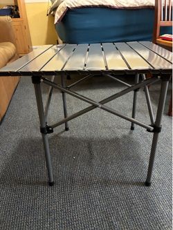 Portable camping table with carrying bag.