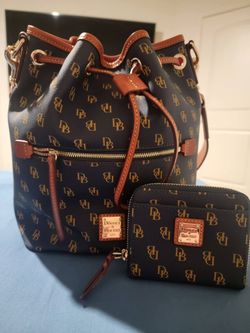 New beautiful drawstring Dooney &Bourke bag with matching wallet in a dark blue with brown trimming  very pretty great mother's day gift