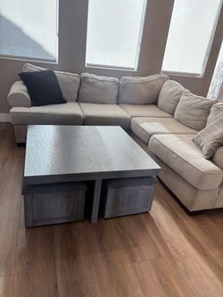 Grey cocktail table with 4 rolling storage stools