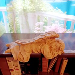 Charming sleeping angel statue for shelf decoration.