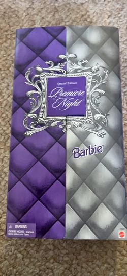 Pristine Barbie doll is in a long purple gown with a silver cape.