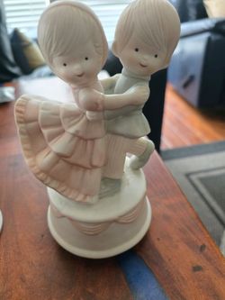 Sweet porcelain figurine of a dancing boy and girl. Soft pastel pink and pale mint green details. Charming vintage-inspired design. Great for shelves 