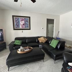 Black sectional and ottoman leather like