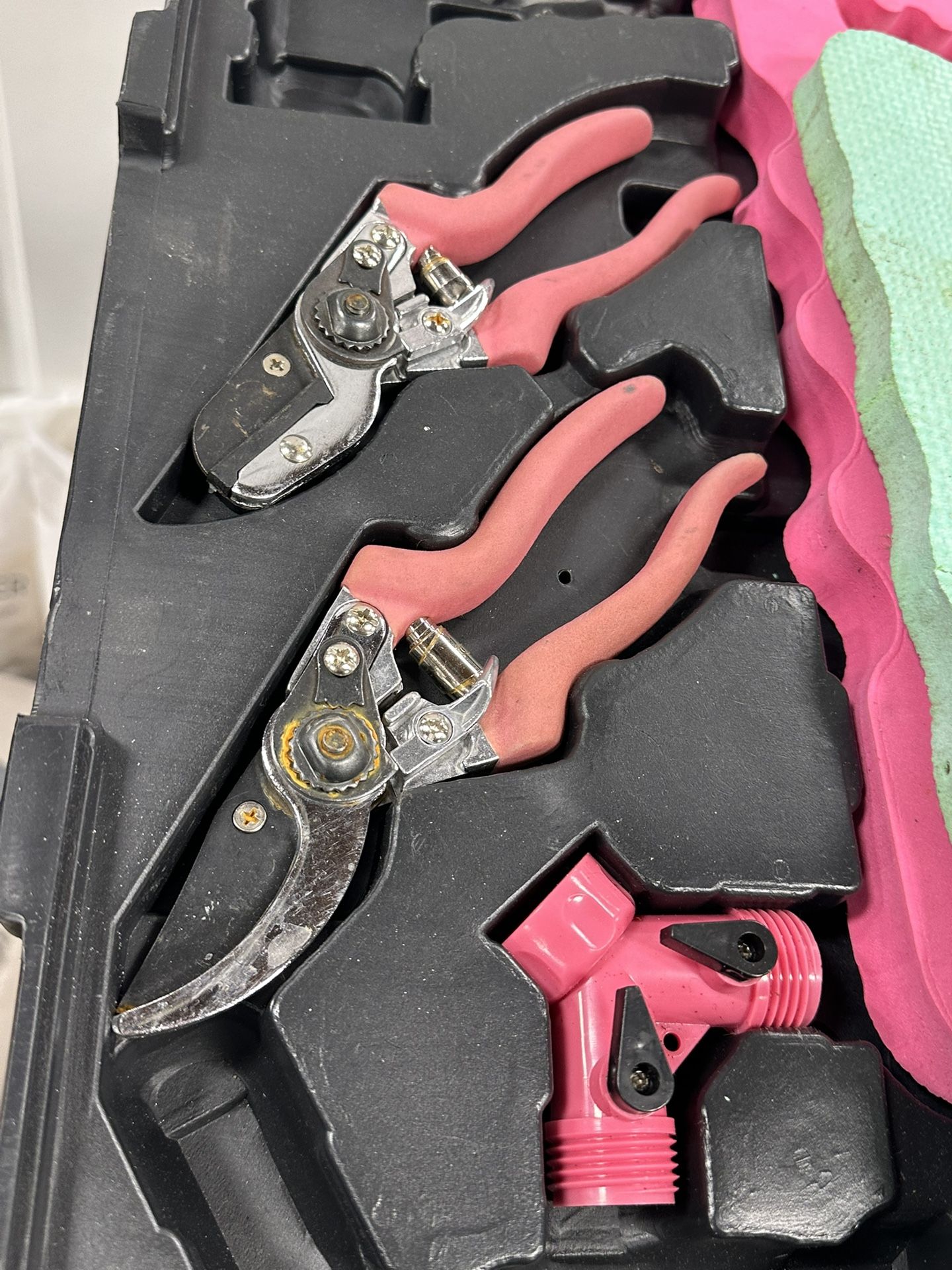 case containing a set of pink-handled gardening tools