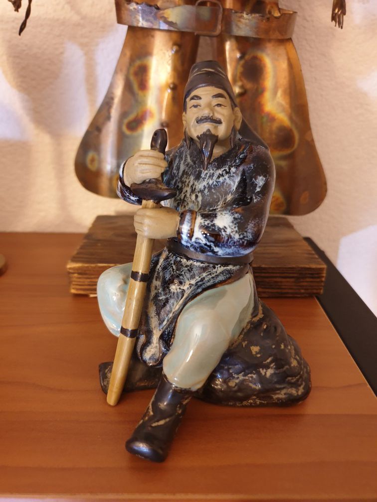 porcelain chimese figure sit on the rock