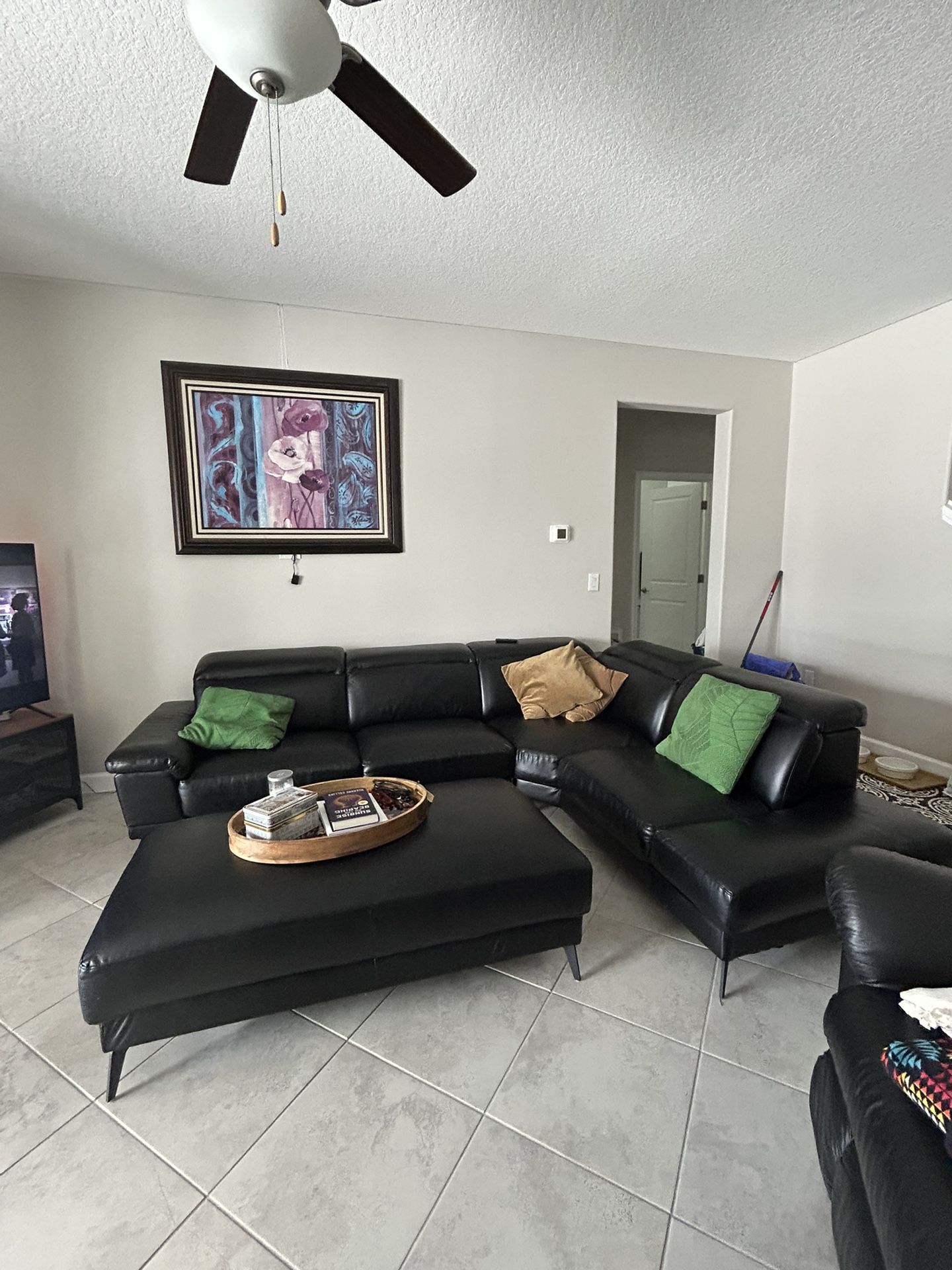 Black sectional and ottoman leather like