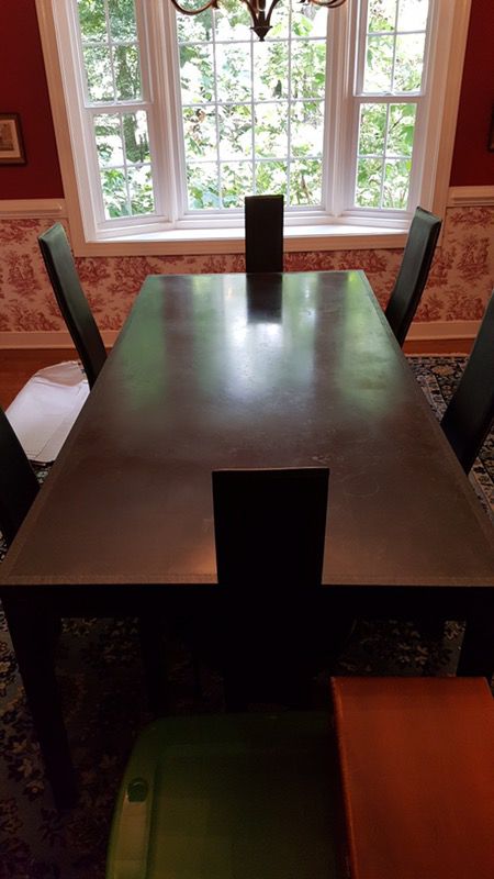 Black slate table with 8 leather chairs.
