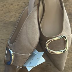 Elegant pointed-toe slip-on flats in a soft tan/beige tone. Designed with a stylish gold accent buckle on the front for a classy, modern look. Lightwe