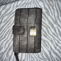 crocodile-embossed bifold wallet designed by Penélope and Mónica Cruz for Carpisa. 