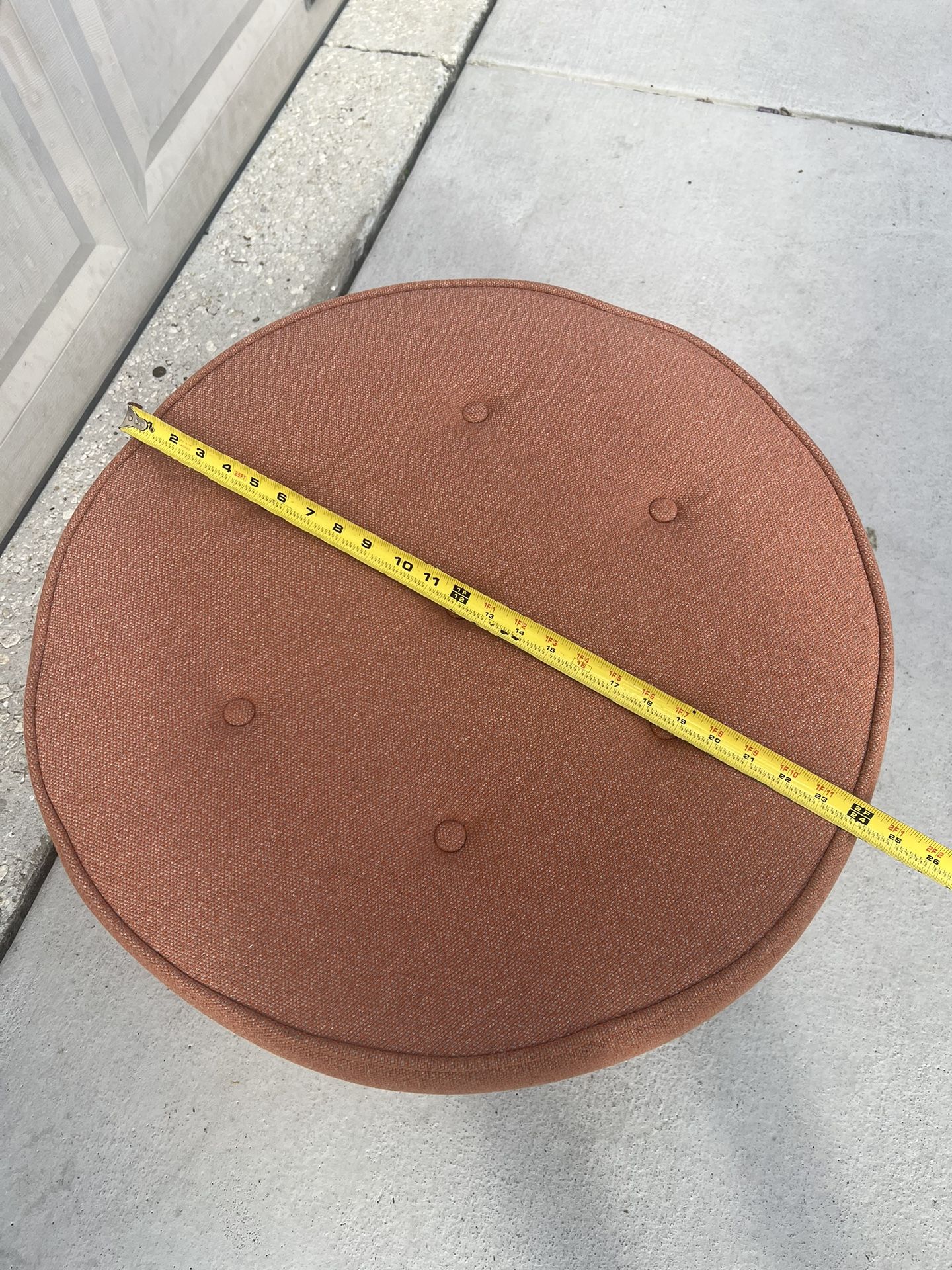 Round Ottoman, peach cloth finish with Brushed Gold Stainless Steel 24 x 17 . Great cosmetic condition with one minor blemishes. There are 4 round scr