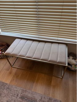 Gold bench with light gray cushion
