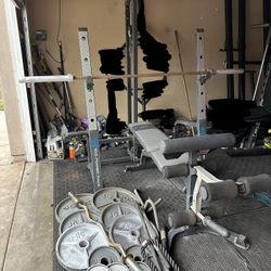 Bench press/squat rack with pulley system and 275lbs of Olympic weights plus curl bar