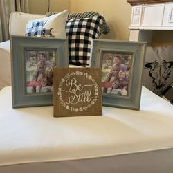 Light blue 5x7 frames and “Be Still” wood decor