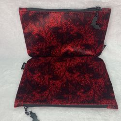 Red and black paisley print makeup bag with a velvet-like feel, featuring a zip closure 
