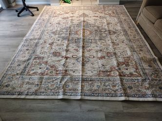 A white Rug  decorated with brown, blue, and light beige.
