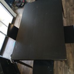 Wooden table with four chairs included