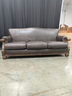 Ornate Brown Leather Couch with Carved Wood Trim