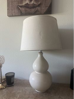 ceramic or porcelain table lamp with a neutral/off-white finish and fabric lampshade