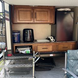 2015 Surveyor with bunk beds on one end of the RV and Queen bed on the other end. It has an outside kitchen and led lights on the awning and cameras.