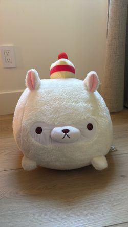 Alpaca plush with strawberry shortcake on head.