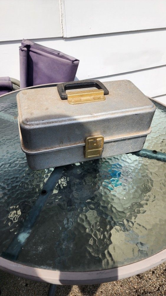 Vintage UMCO 173AS aluminum 3-tray fishing tackle box,
filled with various fishing accessories.