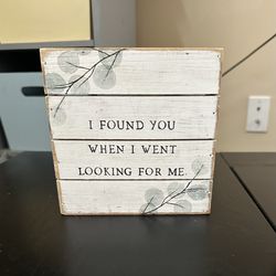 Rustic sign reads "I Found You When I Went Looking For Me”