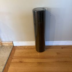 black foam roller used for exercise, muscle recovery, or yoga. 
