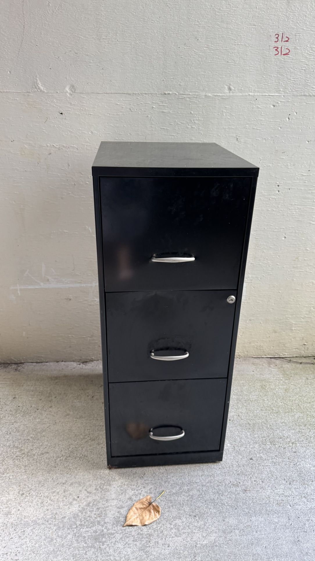 Black three drawer filing cabinet . Keys no included