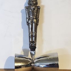 The image shows a Godinger silver-plated Christmas Nutcracker double jigger, used for measuring cocktail ingredients. 