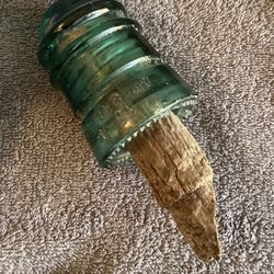 Green Glass Insulator With Piece Of Wood Stuck In It