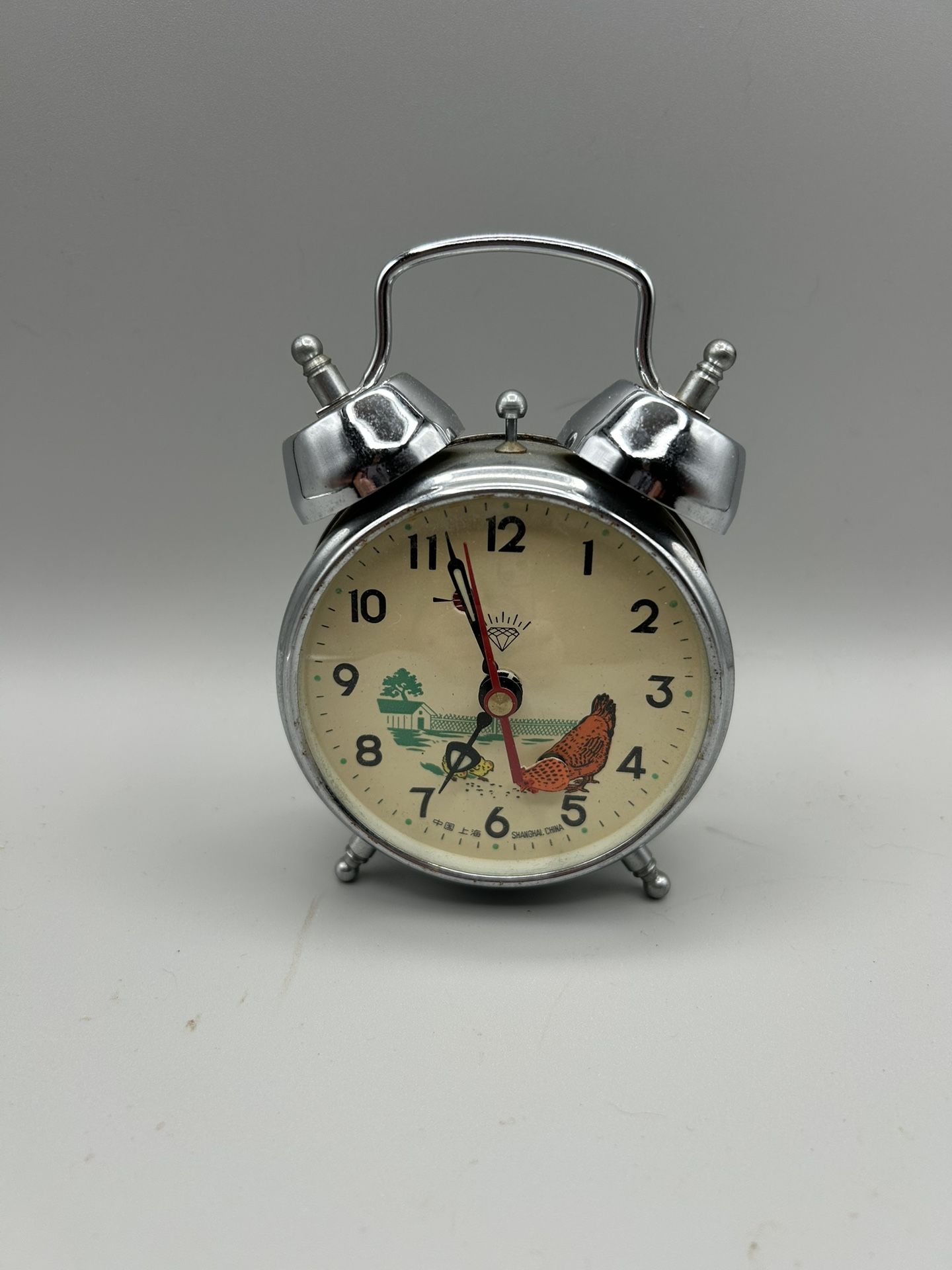 Vintage Shanghai Diamond mechanical twin-bell alarm clock with an animated pecking chicken illustration