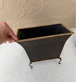 vintage-style metal planter has a dark finish and distinctive gold-colored braided trim along the top edge and base