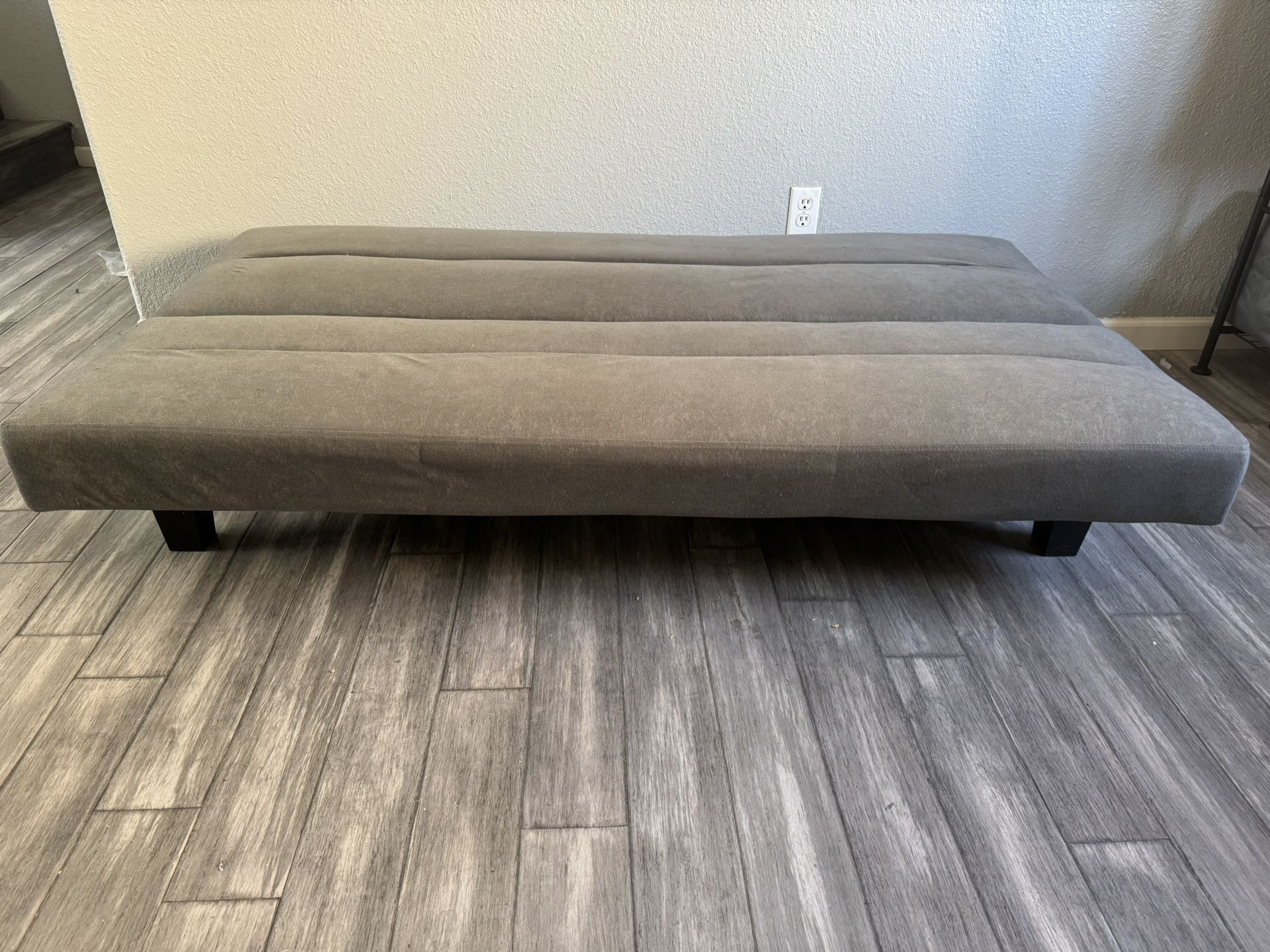 Two gray futons and two cream occasional chairs
