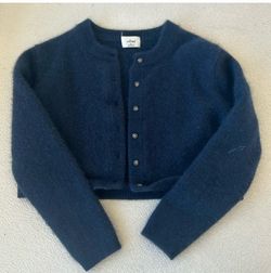 Soft cashmere cropped cardigan with crew neckline. Full-button front for easy styling. Long sleeves and ribbed trim. Classic navy shade for versatile