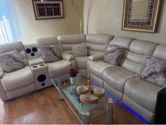 White leather reclining couch with led lights, bluetooth speakers, and console storage