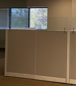 Office Cubicle Workstations – $100 Each  Warm gray 4’ x 6’ office cubicle workstations with white metal framing and clear glass upper privacy panels. 
