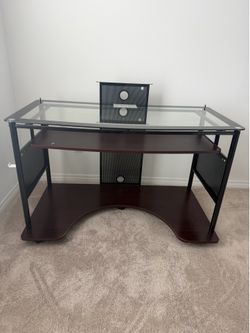 Computer desk with pull-out keyboard tray, metal frame and laminated wood.