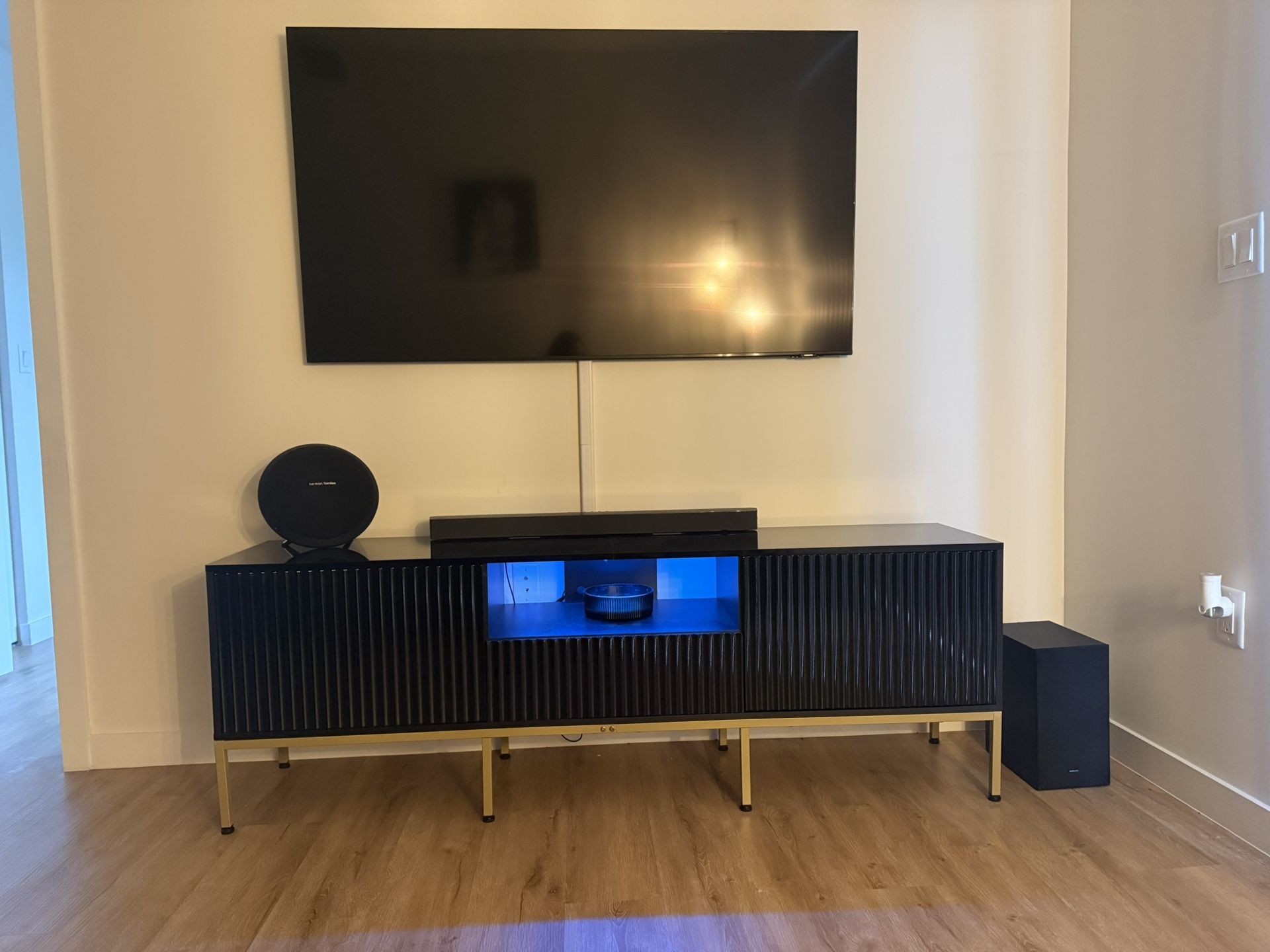 Tv stand with LED lights, storage cabinets, and drawer.