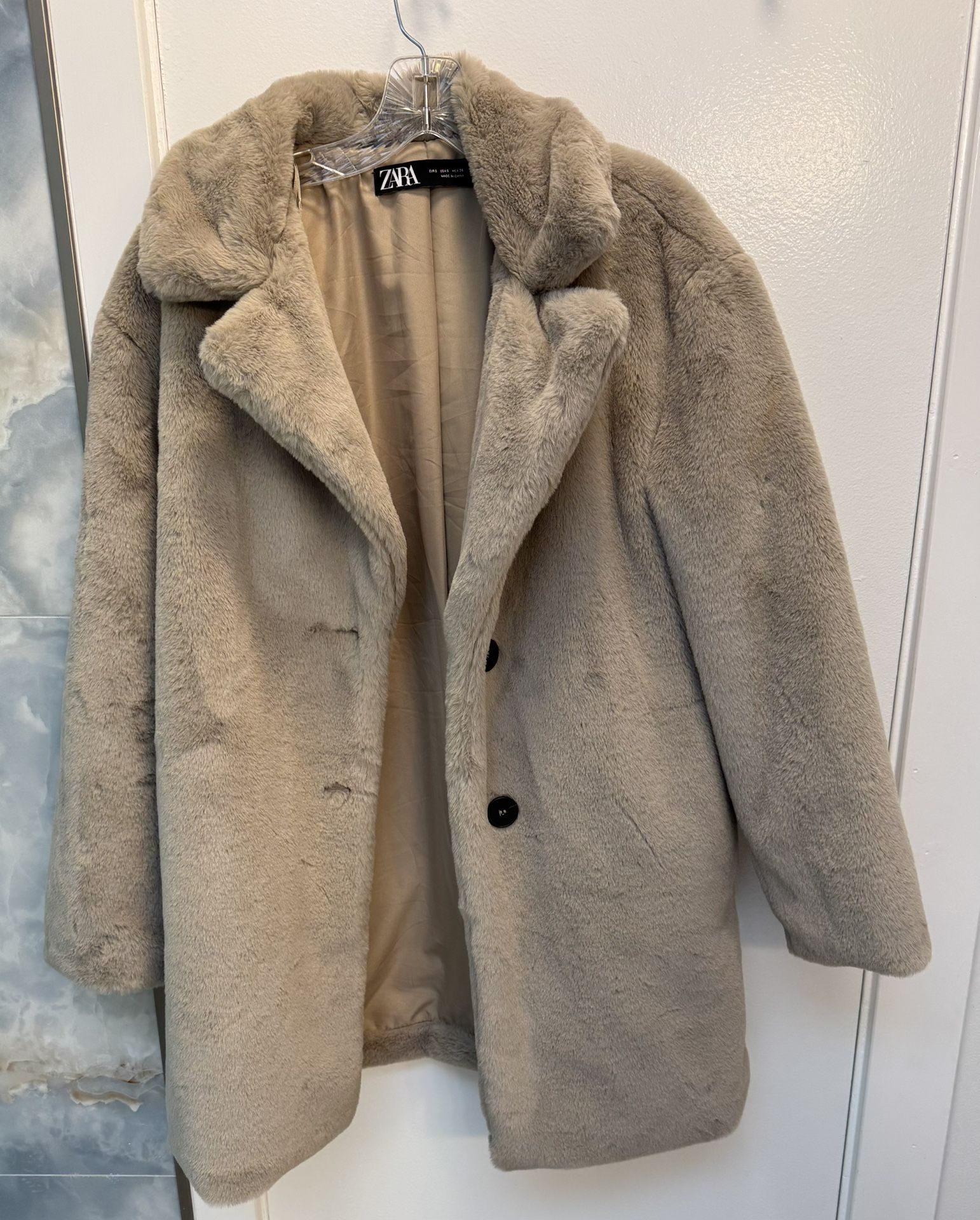 Woman’s Zara faux fur coat light beige with a lapel collar.